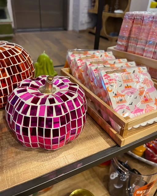 Magenta mosaic pumpkins and colorful gifts on a wooden display