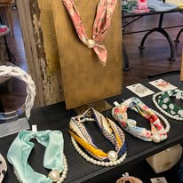 Colorful necklaces and jewelry arranged on Work the Metal's display
